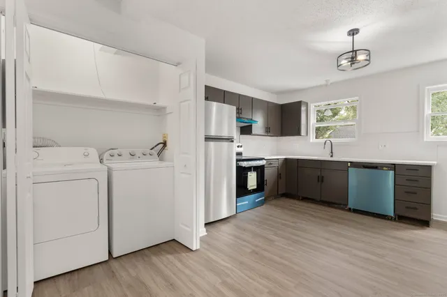 a kitchen with stainless steel appliances granite countertop a sink cabinets and wooden floor