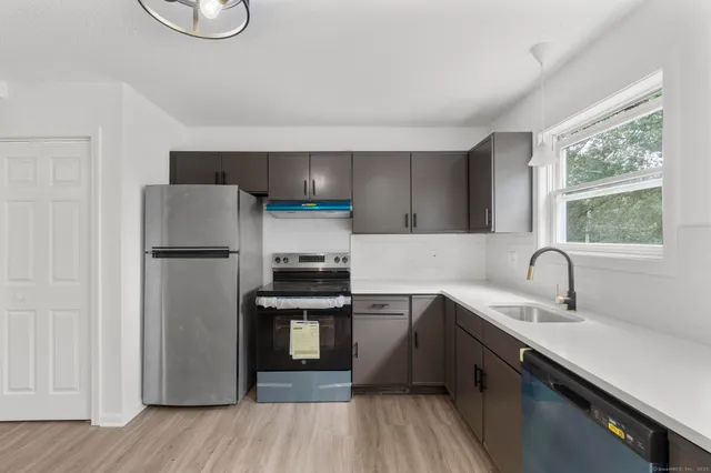 a kitchen with stainless steel appliances granite countertop a refrigerator sink and stove