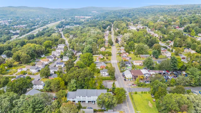 an aerial view of residential houses with outdoor space and trees