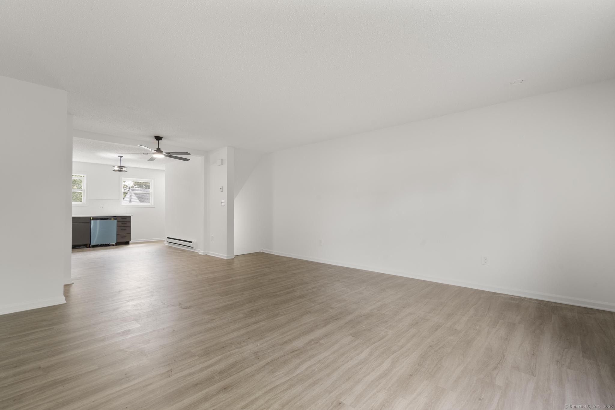 333 Hillside Avenue, Unit 10 Torrington, CT 06790 - Photo 7 of 33 a view of empty room with wooden floor and kitchen