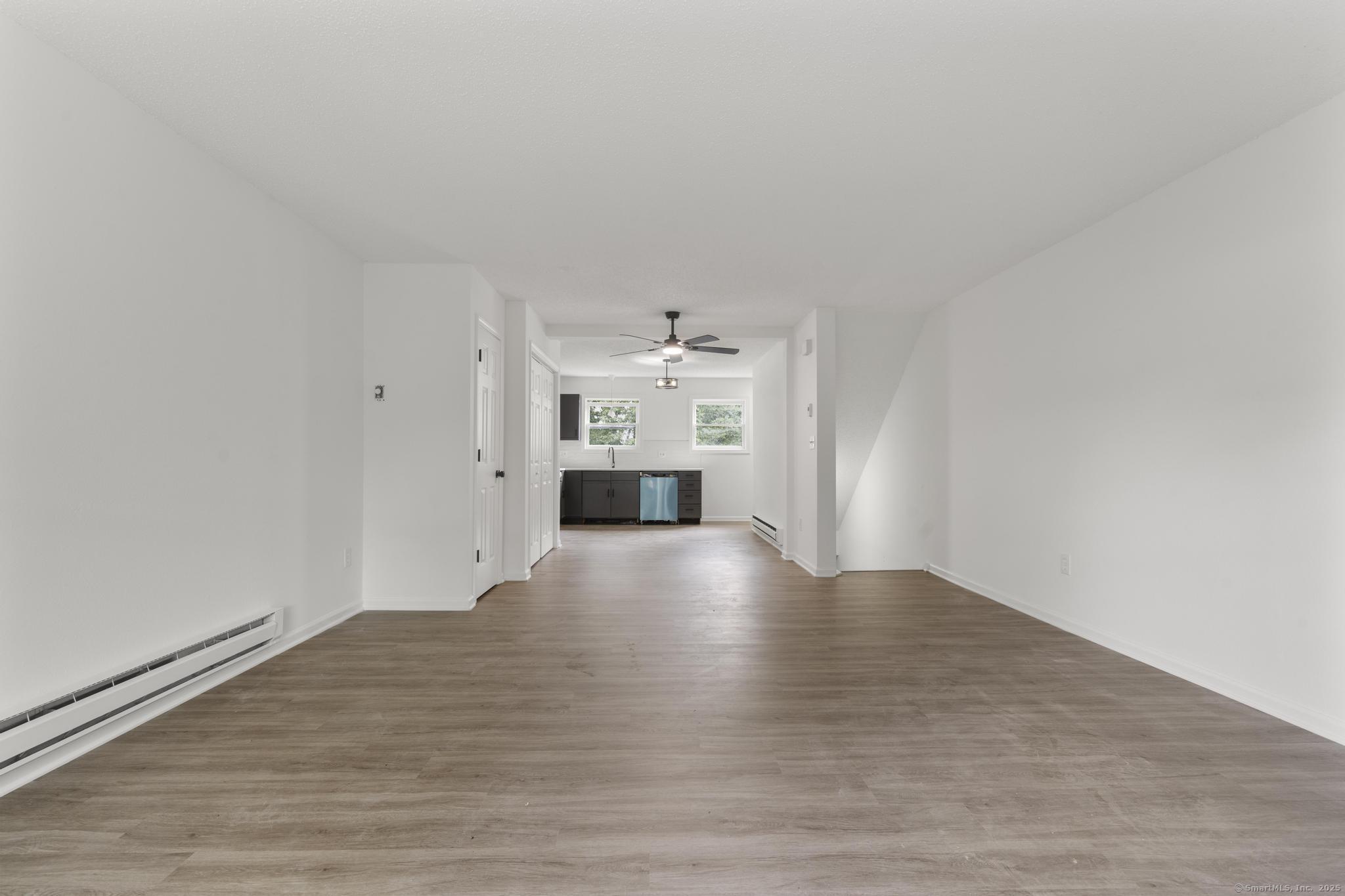 333 Hillside Avenue, Unit 10 Torrington, CT 06790 - Photo 9 of 33 a view of empty room with wooden floor and kitchen