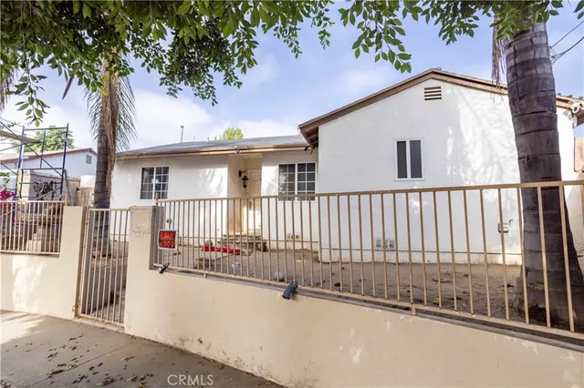 a view of a house with a small yard and wooden fence