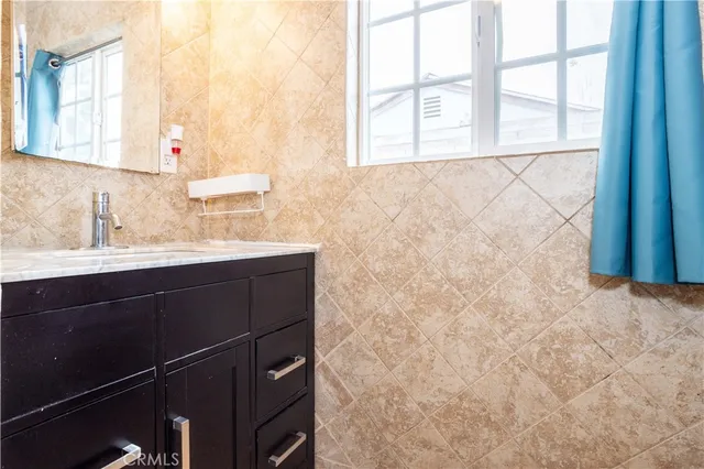 a bathroom with a granite countertop sink toilet and mirror