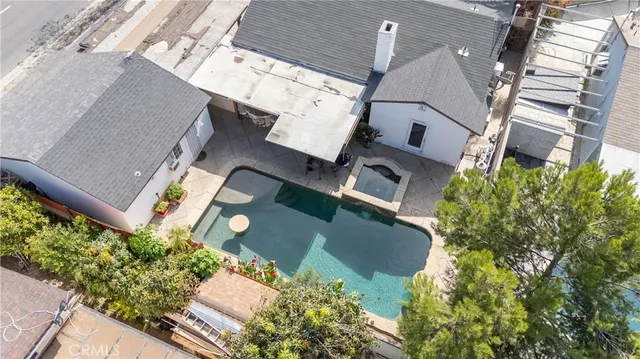 an aerial view of a house with a yard and a large tree