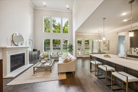 a living room with furniture a large window and a fireplace