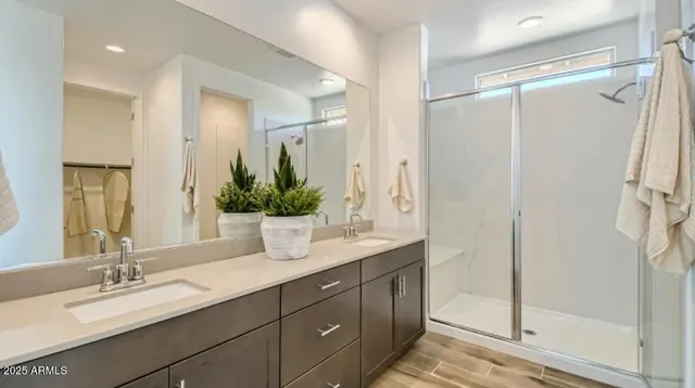 a bathroom with a granite countertop sink a mirror a vanity and a shower