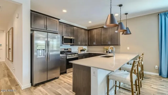 a kitchen with kitchen island a refrigerator stove microwave and cabinets