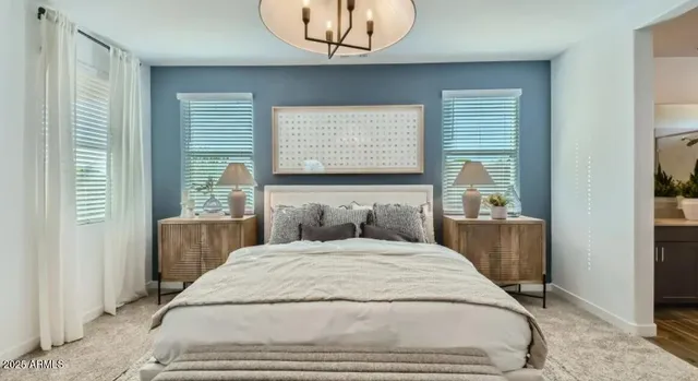 a bedroom with a large bed and windows