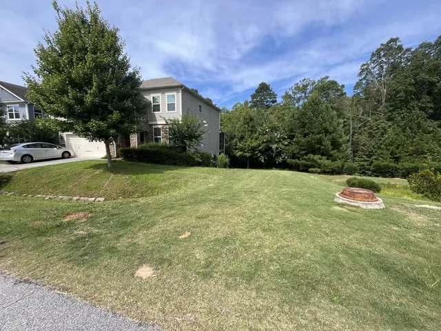 a view of a house with a yard and garage
