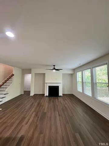 wooden floor fireplace and windows in an empty room