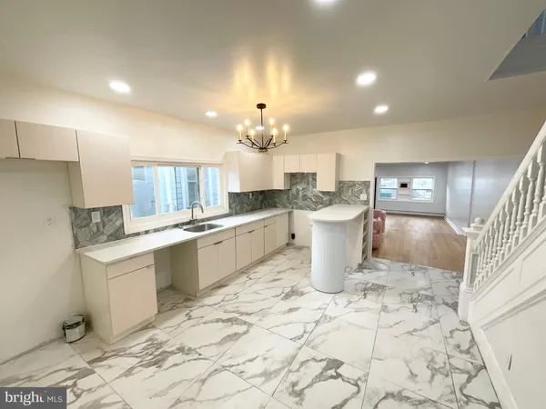 a large white kitchen with a sink and cabinets