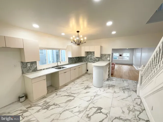 a large white kitchen with a sink and cabinets