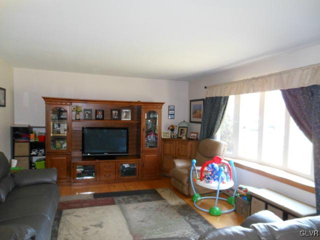 245 Maplewood Road Wind Gap, PA 18091 - Photo 8 of 15 a living room with furniture a flat screen tv and a floor to ceiling window