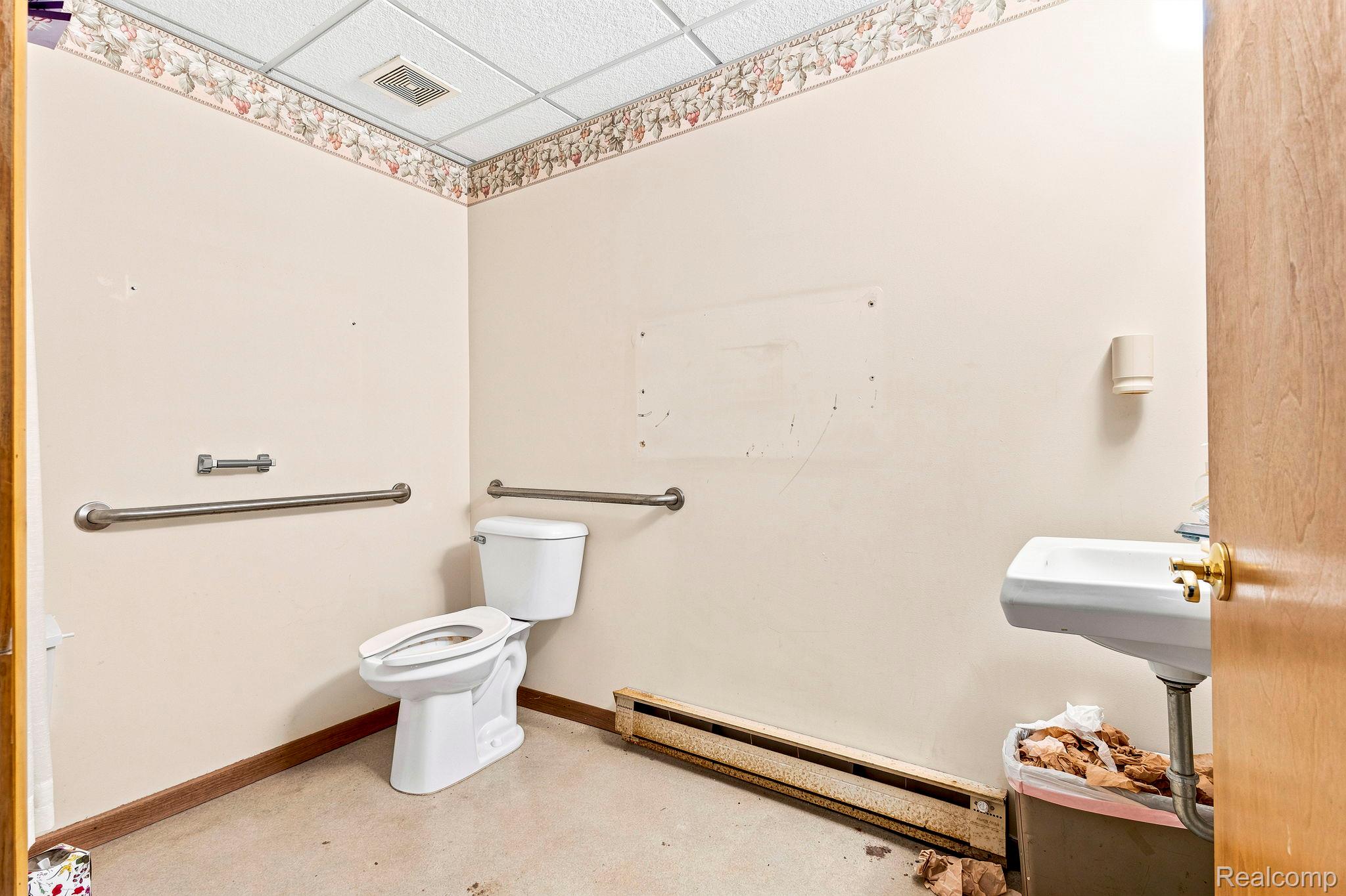 9735 Dolan Road Columbus, MI 48063 - Photo 49 of 63 Restroom featuring a wall-mounted sink, white toilet, and grab bars