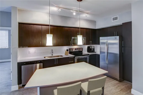 a kitchen with a refrigerator a sink and a counter top space