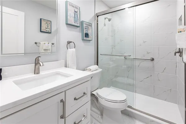 a bathroom with a sink a toilet and shower