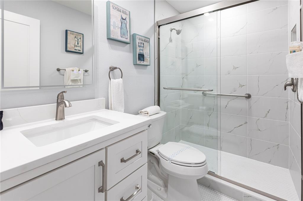 6020 Midnight Pass Road, Unit 30 Sarasota, FL 34242 - Photo 12 of 14 a bathroom with a sink a toilet and shower