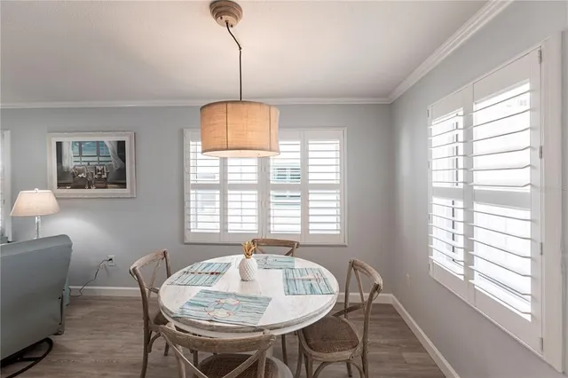 a view of a dining room with furniture a chandelier and wooden floor