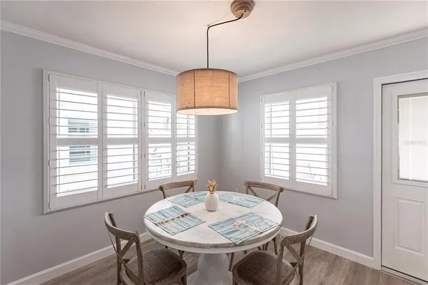 a view of a a dining room with furniture window and wooden floor