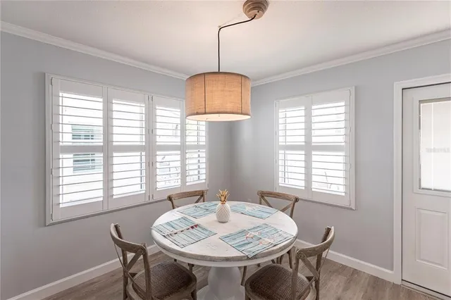 a view of a a dining room with furniture window and wooden floor