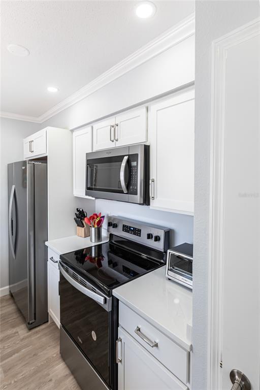 6020 Midnight Pass Road, Unit 30 Sarasota, FL 34242 - Photo 6 of 14 a kitchen with stainless steel appliances a stove microwave and refrigerator