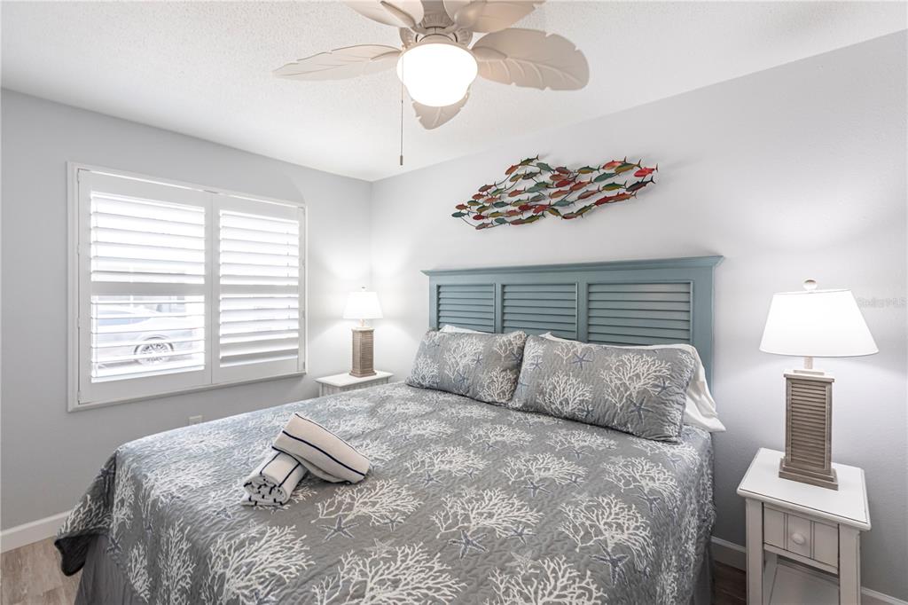 6020 Midnight Pass Road, Unit 30 Sarasota, FL 34242 - Photo 8 of 14 a bedroom with a bed and a chandelier