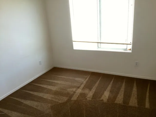 a view of a small space with wooden floor and a window