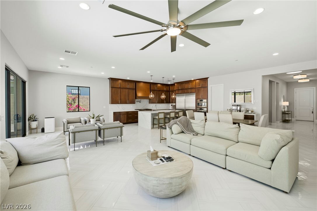 45 Garibaldi Way Henderson, NV 89011 - Photo 8 of 74 An open-concept living area flows seamlessly into a well-appointed kitchen, all beneath a vast ceiling fan.