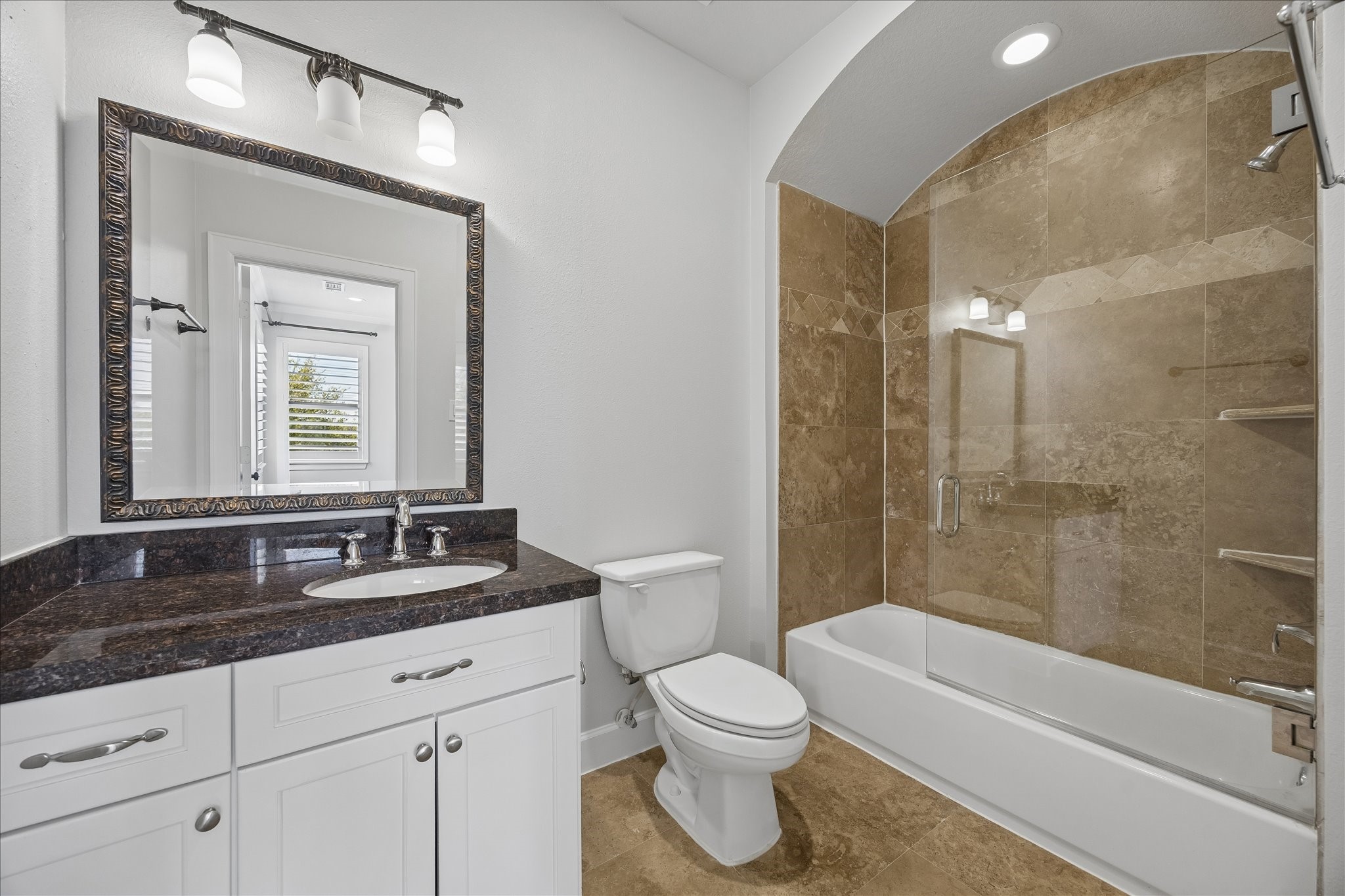 709 Herkimer Street Houston, TX 77007 - Photo 24 of 31 a bathroom with a granite countertop sink toilet a large mirror a bathtub and shower