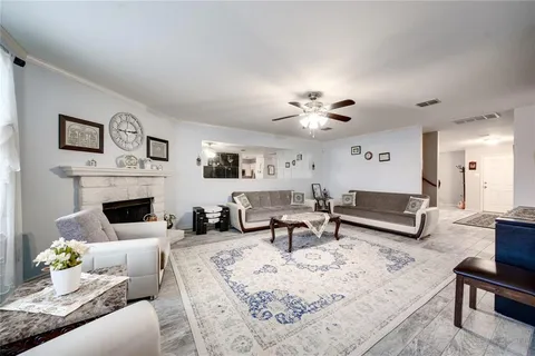 a living room with furniture a fireplace and a chandelier