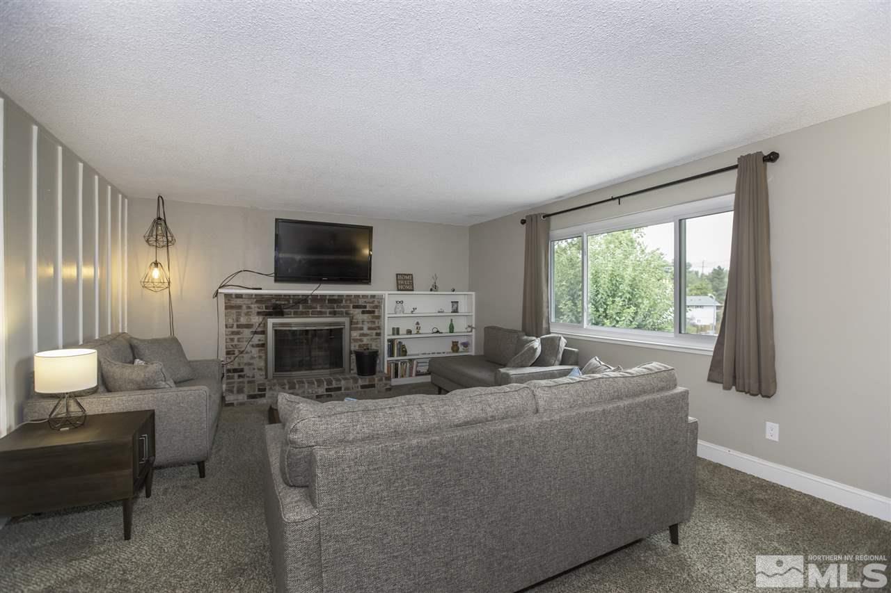 1055 Mark Allen Circle Reno, NV 89503 - Photo 4 of 27 a living room with furniture a fireplace and a flat screen tv