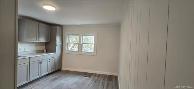 a view of a kitchen with a sink cabinets and wooden floor