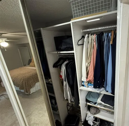 a view of walk in closet with clothes and shoes