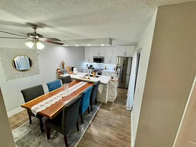 a room with stainless steel appliances a stove a refrigerator a couch and cabinets