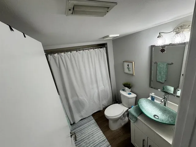 a bathroom with a granite countertop sink toilet and shower