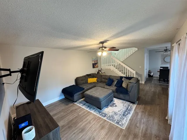 a living room with furniture and a wooden floor