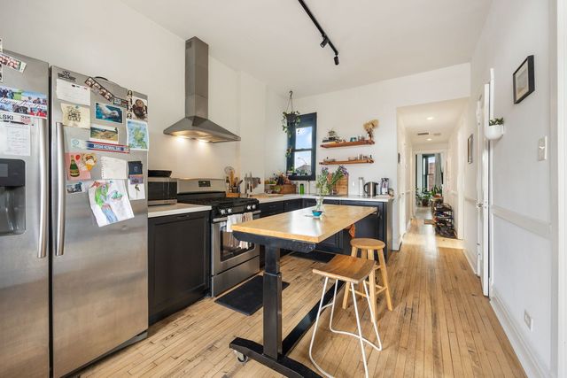 a kitchen with stainless steel appliances granite countertop a refrigerator a sink dishwasher and a stove with wooden floor