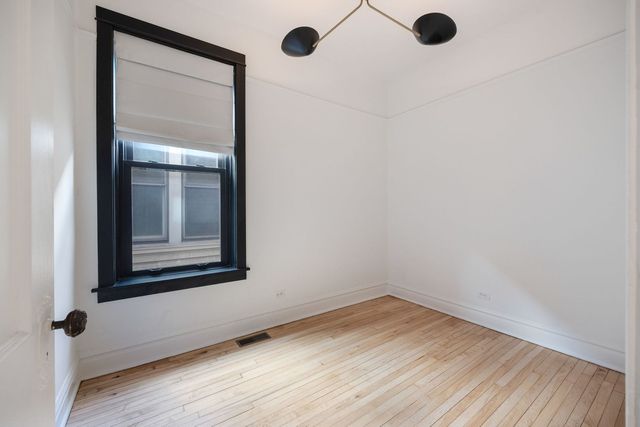 a view of a small space with wooden floor and a window