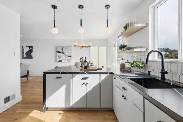 a kitchen with stainless steel appliances granite countertop a sink a stove and a wooden floors