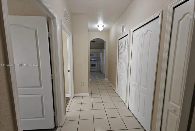 a view of a hallway with wooden floor and closet area