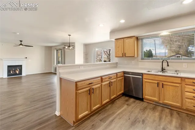 a kitchen with stainless steel appliances granite countertop a sink a stove a refrigerator and island with wooden floor
