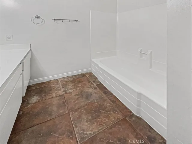 a view of an empty room with closet and a window