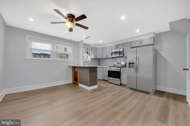 a kitchen with kitchen island white cabinets and stainless steel appliances