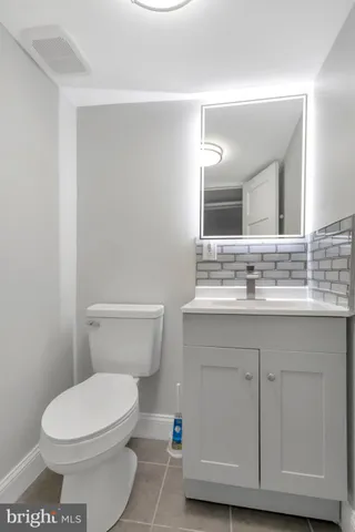 a bathroom with a sink a toilet a mirror and vanity