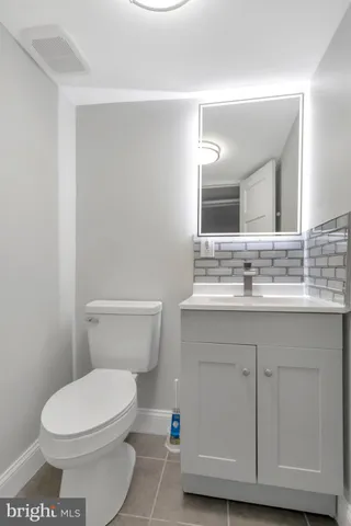 a bathroom with a sink a toilet a mirror and vanity