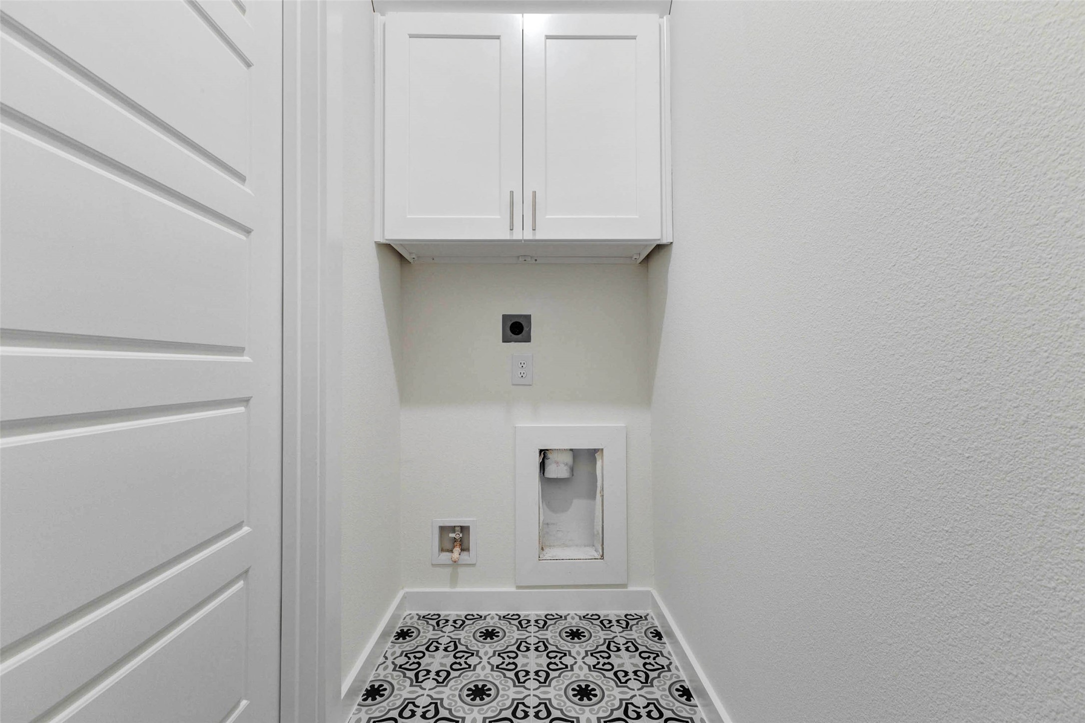 6471 Escondido Drive Rosharon, TX 77583 - Photo 16 of 33 Convenient in-home utility space with washer and dryer connections, overhead storage cabinetry, patterned tile flooring, and a clean, tucked-away layout. This dedicated laundry area keeps everyday chores organized while offering useful cabinet storage for detergents, linens, or household supplies.