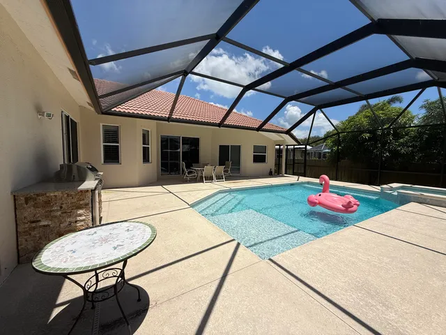 a patio with a table and chairs and potted plants