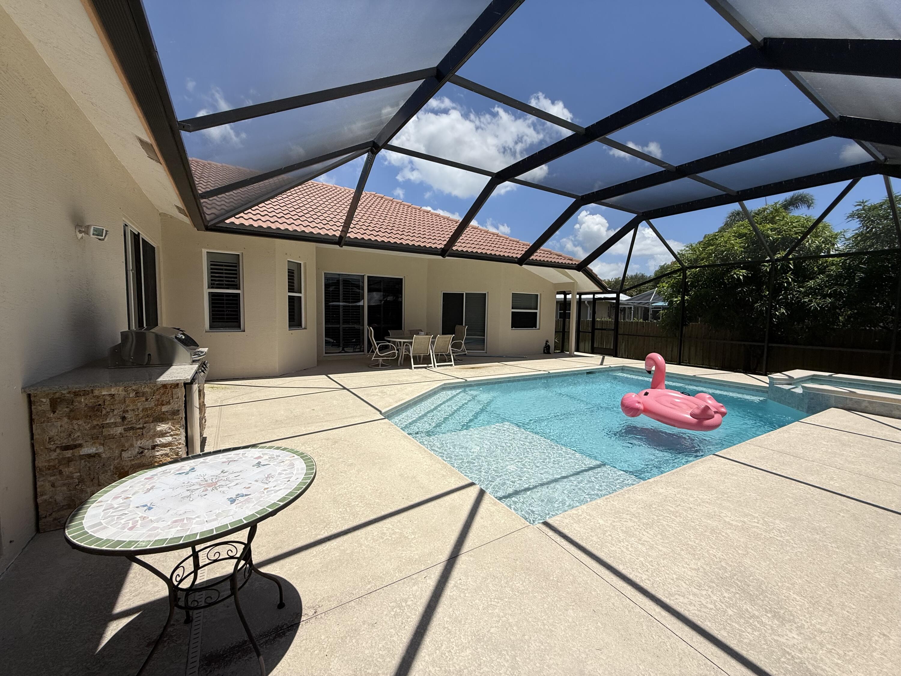 2810 Southeast Tate Avenue Port St. Lucie, FL 34984 - Photo 11 of 43 a patio with a table and chairs and potted plants