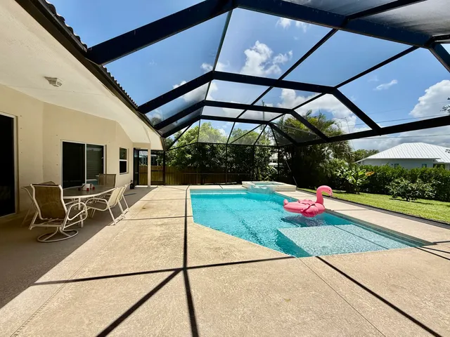a view of a patio with table and chairs under an umbrella