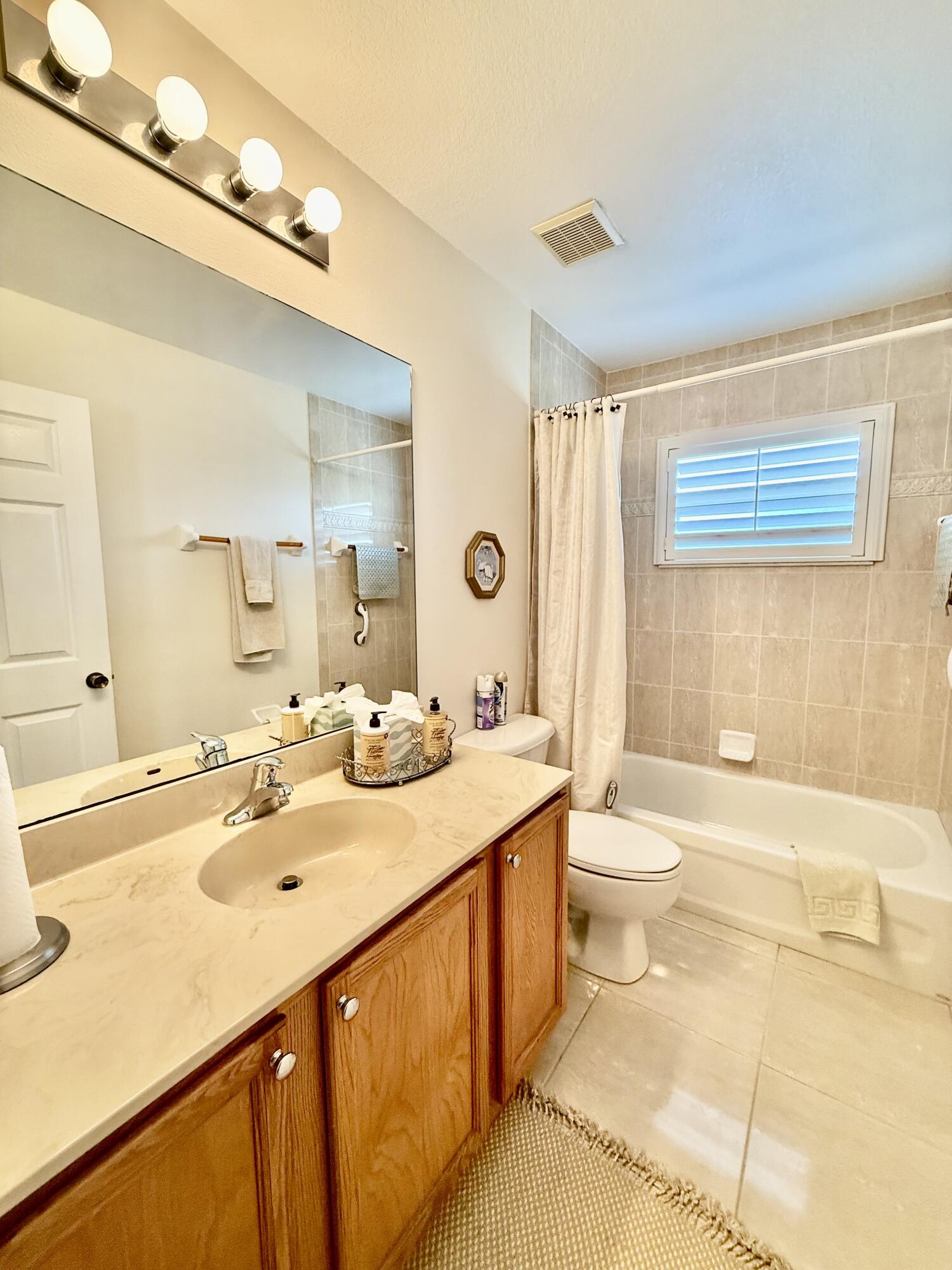 2810 Southeast Tate Avenue Port St. Lucie, FL 34984 - Photo 26 of 43 a bathroom with a double vanity sink toilet mirror and bathtub